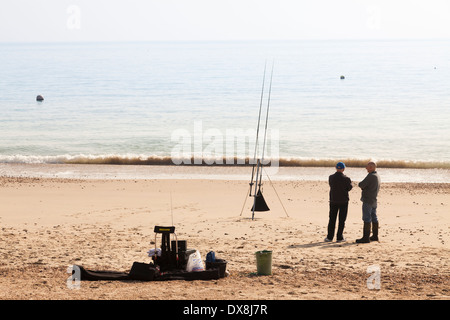 Deux hommes pêche en mer à partir de la plage. Banque D'Images
