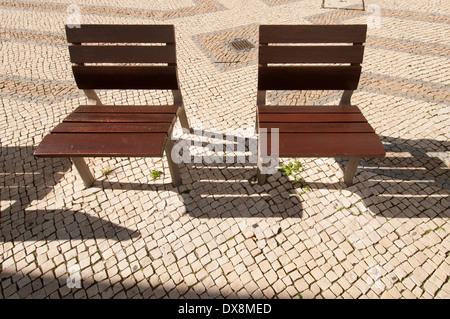 Deux chaises en bois sur une vieille rue pavée de Faro Portugal Banque D'Images