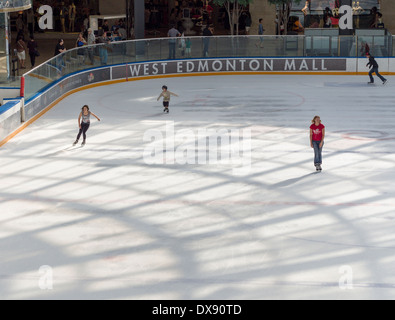 Skating au West Edmonton Mall Ice Palace. Quatre jeunes gens prendre à la grande surface de la glace à l'intérieur de cet immense centre commercial d'Edmonton. Banque D'Images