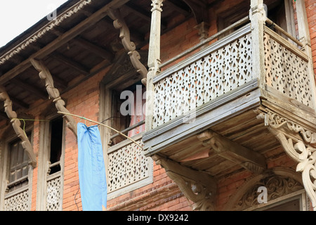 Vieille maison en brique rouge dans le style Newari traditionnel avec balcon en bois sculpté-windows-équilibreurs de toit de parapets. Bandipur-Nepal. Banque D'Images