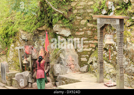 Fidèles hindous femme prie à un Seigneur Hanuman's statue à l'entrée de la grotte-temple Gorakhnath. Durbar-Nepal Gorkha. Banque D'Images