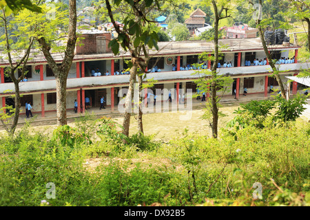 L'école publique locale avec les élèves de retourner en classe après la récréation. Bazaar-Nepal Gorkha. Banque D'Images