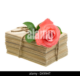 Pile d'anciennes lettres d'amour et cartes postales avec fleur rose rose isolé sur fond blanc. Photo sentimental nostalgique Banque D'Images