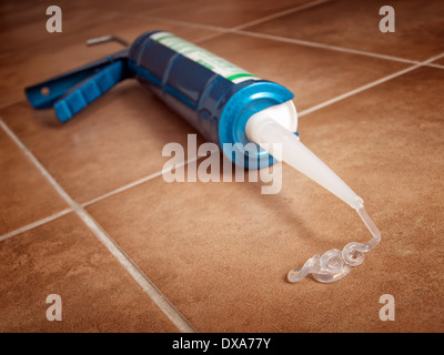 Vue rapprochée d'un pistolet de silicone sur le sol. Banque D'Images
