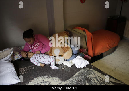 Madrid, Espagne. Mar 21, 2014. Liseth Saavedra Carranza, 22, nourrit sa fille 11 mois - vieux Daniela Chasi Saavedra, puisque sa famille a attendre que la commission judiciaire et de la police d'arriver pour leur expulsion, à Madrid, Espagne, le vendredi 21 mars 2014. Daniela vit avec sa sœur, ses parents, deux oncles et ses grands-parents. La Chasi Sanguna, famille originaire de l'Équateur, a acheté un euro 259 000 (US$ 357 453) appartement en prenant un prêt hypothécaire auprès de la banque Bankia en 2004, mais ils ont cessé d'effectuer des paiements après Daniela's oncles ont perdu leur emploi dans le secteur de la construction en 2010 et son père Banque D'Images