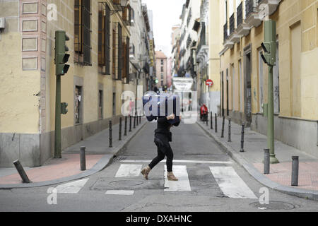 Madrid, Espagne. Mar 21, 2014. Un piéton porte ses bagages, elle croise la route de Madrid, Espagne, Vendredi, 21 mars 2014. © Rodrigo Garcia/NurPhoto ZUMAPRESS.com/Alamy/Live News Banque D'Images