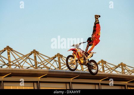 Dirt bike volant par l'air, les pieds en l'air tirant une stunt Banque D'Images