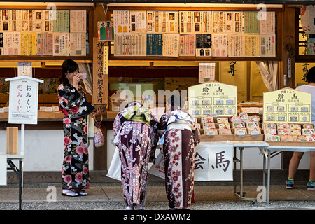 Amis de kimonos à Yasaka (Ema vente plaques en bois pour des rêves) et Omamori (charmes et talismans), Kyoto, Japon Banque D'Images