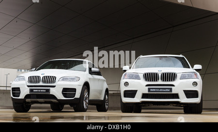 Deux nouveaux white BMW X3 et X6 SUV présenté dans BMW Welt show. Voitures sur podium humide après la pluie. Banque D'Images