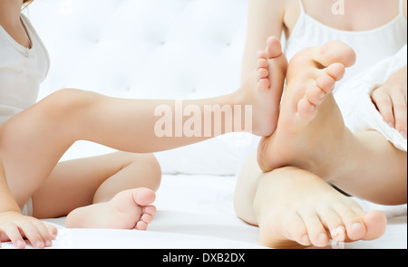 Les pieds de la famille dans le lit Banque D'Images