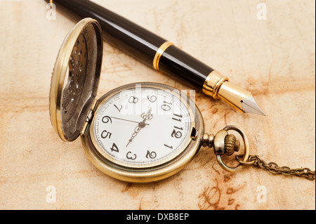 Stylo plume et pocketwatch sur vieux parchemin Banque D'Images