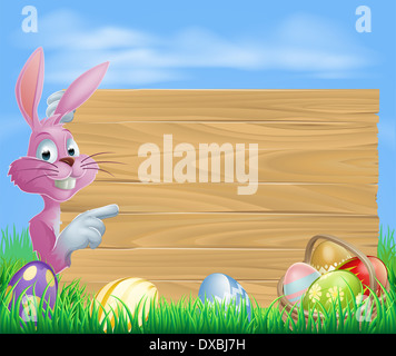 Les oeufs de Pâques lapin rose avec du chocolat et des oeufs de Pâques peints en blanc d'un panneau en bois Banque D'Images