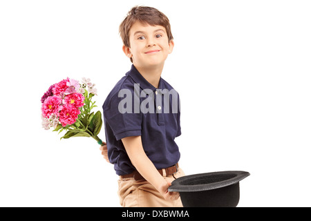 Smiling kid holding bouquet de fleurs et un chapeau Banque D'Images