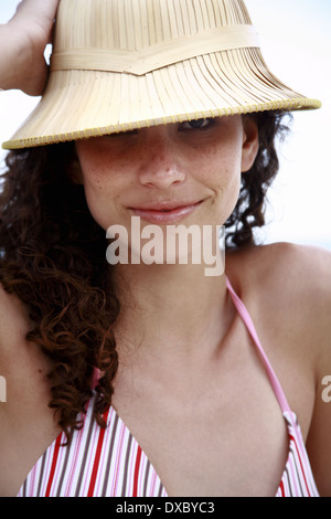 Jeunes adultes femelles portant chapeau de soleil sur la plage Banque D'Images