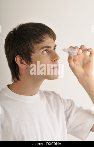 Les jeunes adultes de sexe masculin avec bouteille de gouttes Banque D'Images