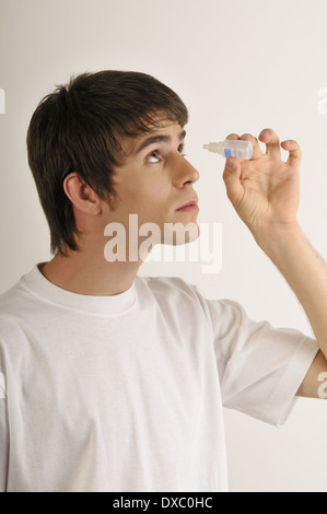 Les jeunes adultes de sexe masculin avec bouteille de gouttes Banque D'Images