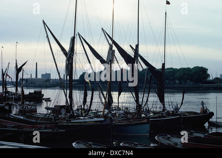 Des barges de la Tamise ont été silhououtés contre la rivière avec la centrale électrique de Bankside en arrière-plan, en soirée, 1973, de Wapping, de l'autre côté de la Tamise Banque D'Images