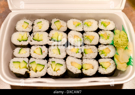 Rouleaux de sushi végétarien ou végétalien- l'avocat et le concombre en petits pains de polystyrène pour emporter le contenant. Banque D'Images