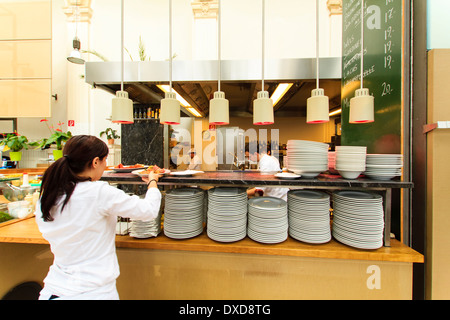 À l'intérieur de 'Palmenhouse' restaurant situé dans la serre près de la Hofburg. Serveuse ramasser des plats prêts à être servis Banque D'Images