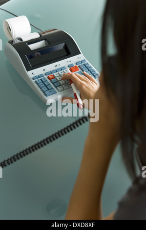 Femme professionnelle sur téléphone using calculator Banque D'Images