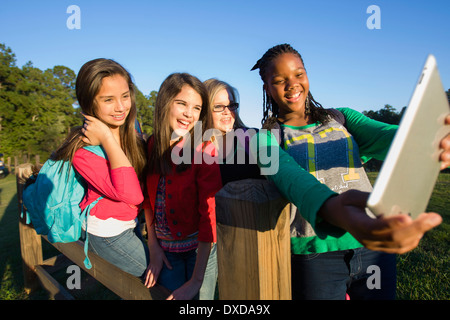 Pre-teen girls standing outdoors, looking at tablet computer rire, Florida, USA Banque D'Images