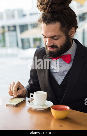 Élégant élégant dreadlocks man au bar en paysage des affaires Banque D'Images