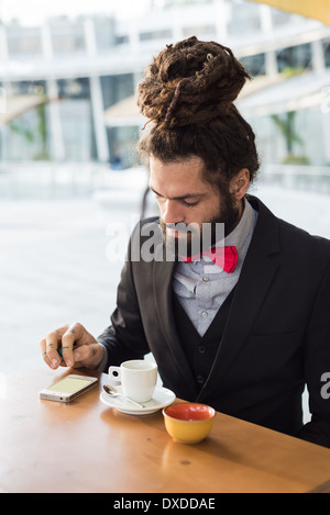 Élégant élégant dreadlocks man au bar en paysage des affaires Banque D'Images