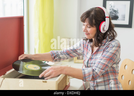 Woman listening to music on antique record player Banque D'Images