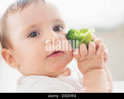 Baby Girl (4-5) holding broccoli Banque D'Images