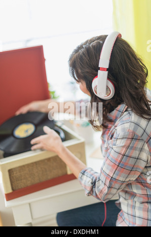 Woman listening to music on antique record player Banque D'Images