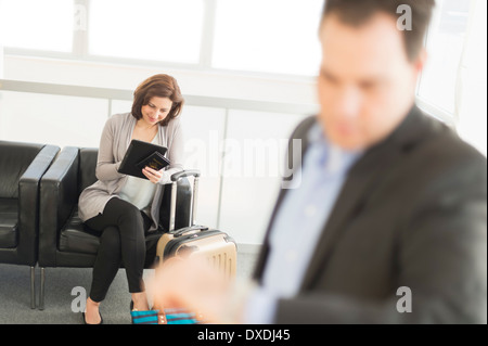 Businessman and businesswoman en attente de voyage a l'aéroport Banque D'Images