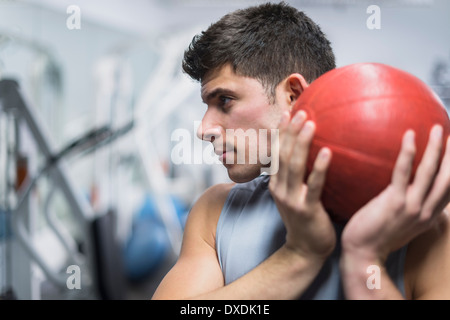 Jeune homme à gym holding medicine ball Banque D'Images