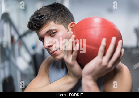 Jeune homme à gym holding medicine ball Banque D'Images