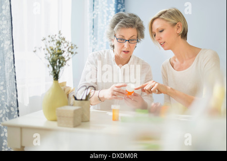 Infirmière et femme mature lire les étiquettes sur medicine bottle Banque D'Images