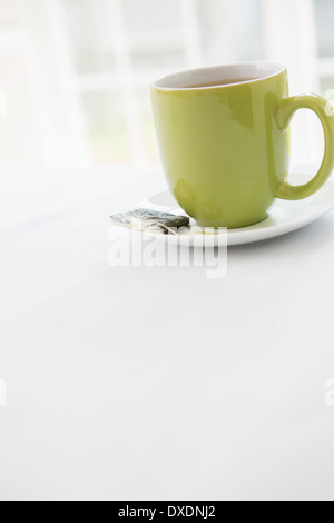 Utilisé sur un sachet de thé avec soucoupe tasse de thé vert dans une tasse, Studio Shot Banque D'Images