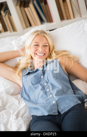 Portrait of young woman relaxing in bedroom Banque D'Images
