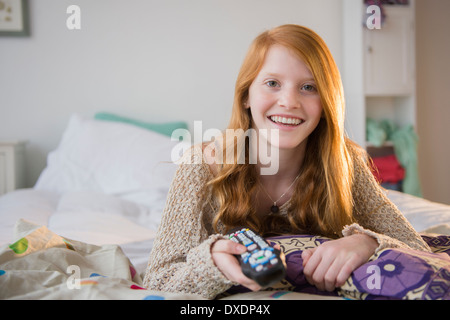 Portrait of Girl (12-13) lying on bed Banque D'Images