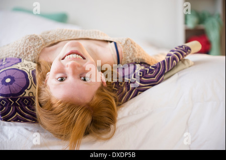 Portrait of Girl (12-13) lying on bed Banque D'Images