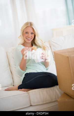 Portrait of young woman eating Chinese food Banque D'Images