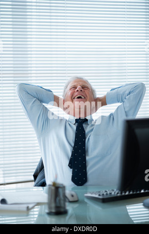 Senior man relaxing in office Banque D'Images