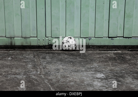 C'est une photo d'un ballon de basket-ball sur un plancher de béton rugueux. C'est un kid balle pour jouer et jeux Banque D'Images