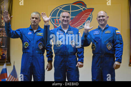 Équipage expédition 39 équipage primaire, de gauche à droite, l'astronaute Steve Swanson de NASA, commandant de Soyouz Aleksander Skvortsov de l'Agence spatiale fédérale russe, et le cosmonaute Oleg Artemyev de Roscosmos vague de derrière une vitre en quarantaine à l'hôtel cosmonaute le 24 mars 2014 à Baïkonour, au Kazakhstan. Lancement de la fusée Soyouz est prévue pour le 26 mars et envoie le groupe sur une mission de six mois à bord de la Station spatiale internationale. Banque D'Images