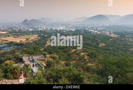 Le lac sacré niché entre les collines Aravalli comme personnes monter une colline à entrevoir une meilleure vue à Pushkar, Inde. Banque D'Images