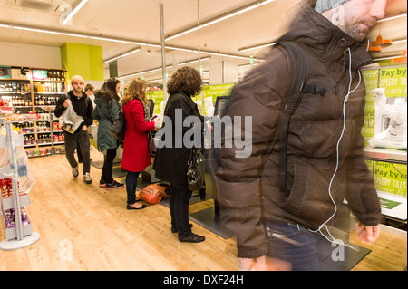 Shopper à l'auto-service check out laboure dans le Caveau Boutique, Old Street, Londres EC1V, au Royaume-Uni. Banque D'Images