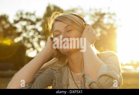 Jeune femme à l'écoute de la musique avec des écouteurs, Mannehim, Baden-Wurttemberg, Allemagne Banque D'Images