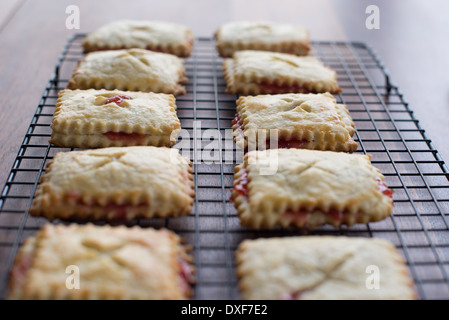 La rhubarbe Tartelettes aux fraises sur une grille de refroidissement Banque D'Images