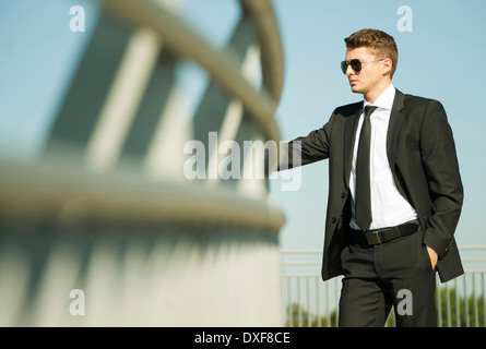 Portrait of businessman standing by railing and looking at view, Allemagne Banque D'Images