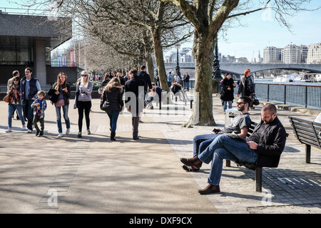 Les gens se détendre au soleil sur la rive sud de Londres. Banque D'Images