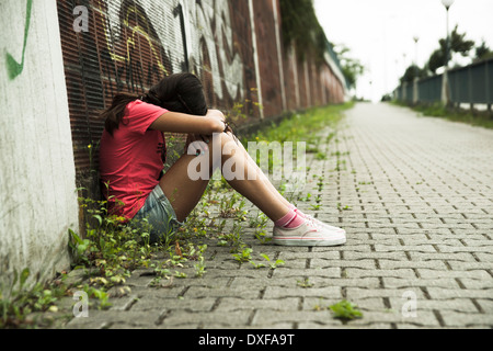 Fille assise sur la masse dans Alley, Mannheim, Baden-Wurttemberg, Germany Banque D'Images