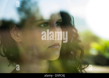 Close-up portrait of teenage girl looking out window, Allemagne Banque D'Images